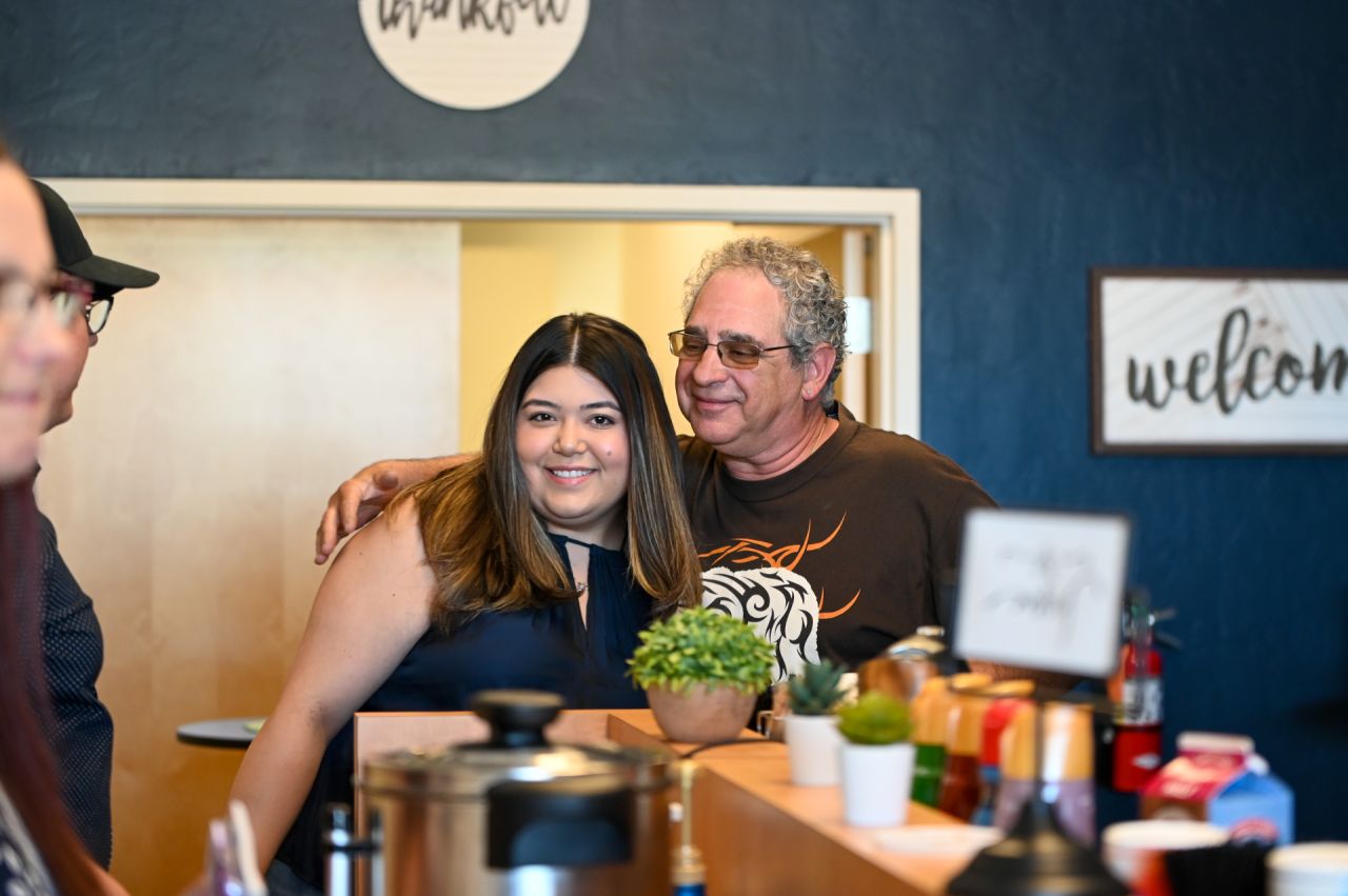 Two friends smiling and chatting at the church coffee bar